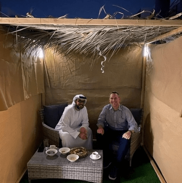 2 men sitting together in a Sukka