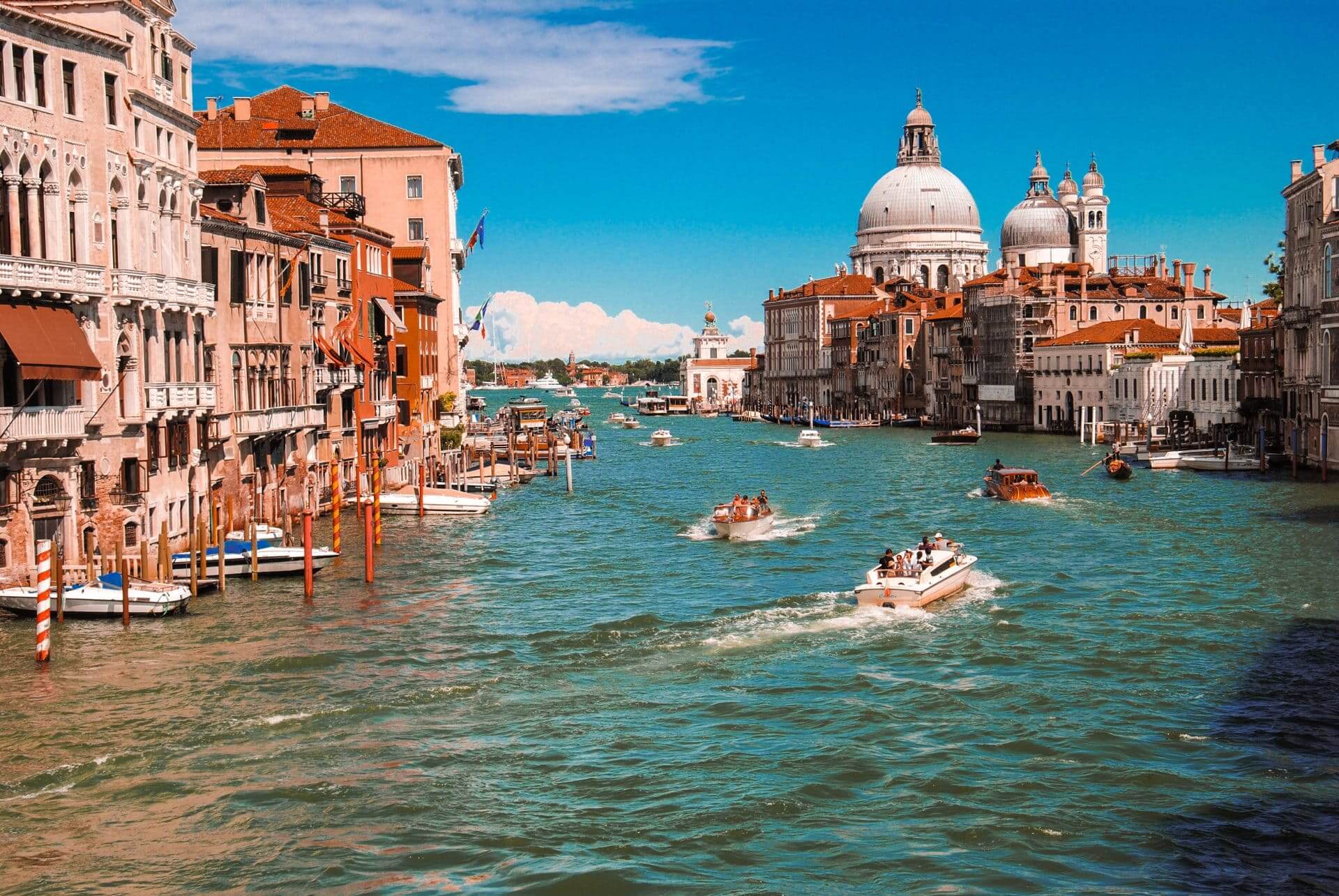 Venice on a Jewish heritage tour of Italy. Several boats flow through a main canal in the Metropolitan city of venice